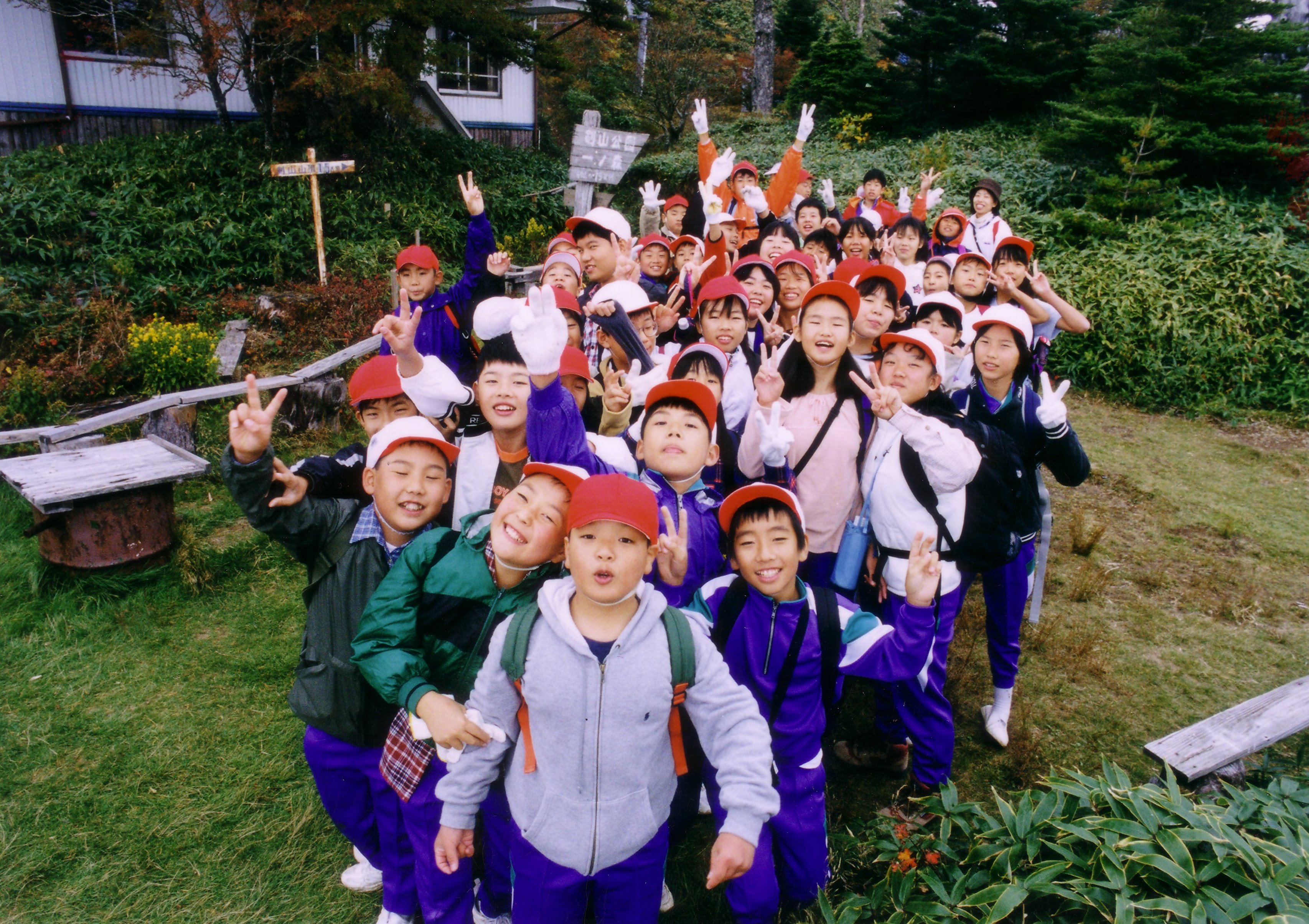 剣山地の一ノ森に登頂し、ピースサインをする35人の小学6年生。