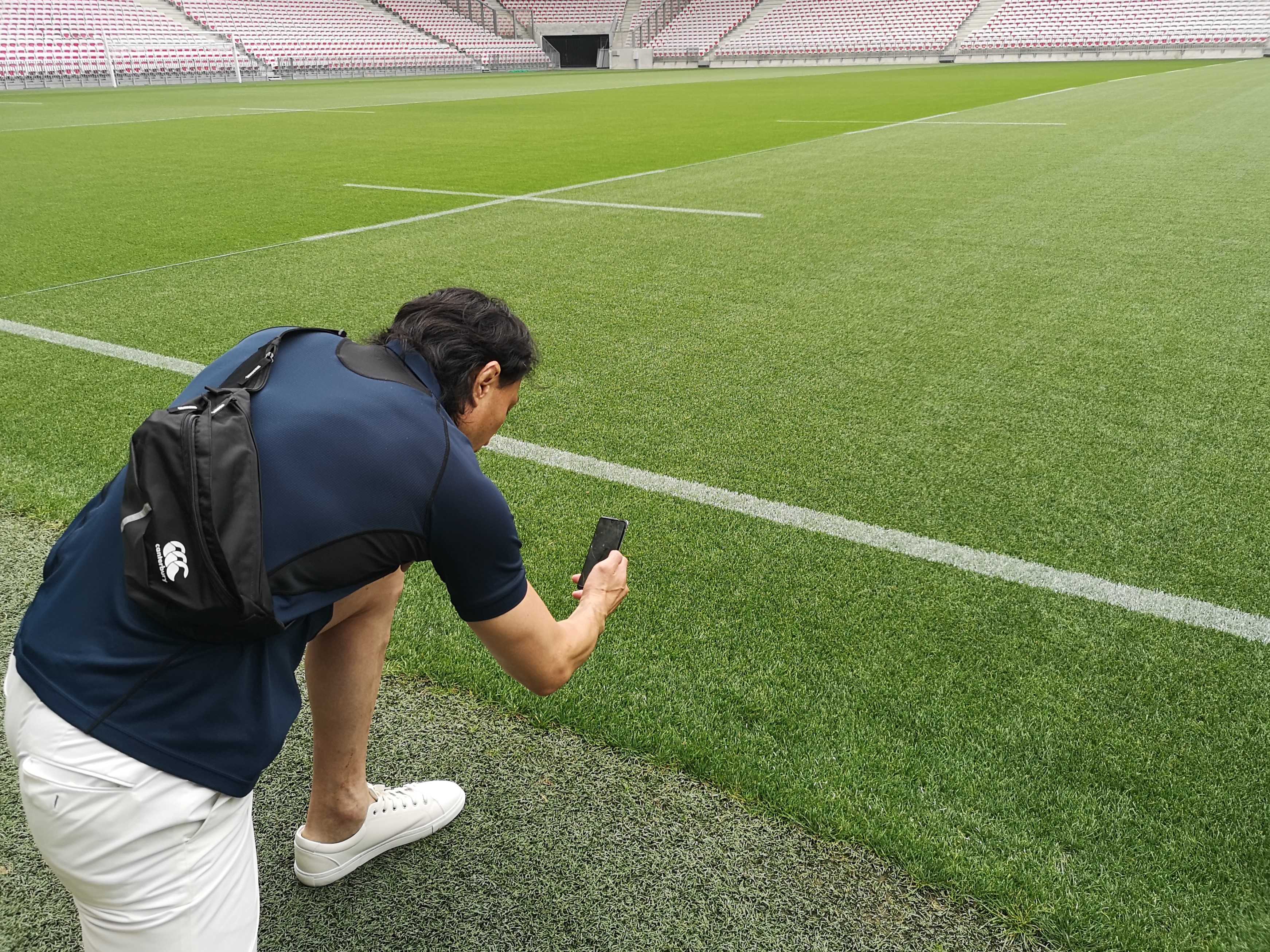 アリアンツ リヴィエラスタジアムで芝を観察する大野さん。