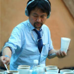 サザコーヒー代表 鈴木太郎　コーヒーの品評会で審査員をするのが好きで、パナマ・ゲイシャのコーヒーの品評会に毎年参加している。ヘッドホンは集中したコーヒーの味の審査で周りの雑音を消すためにノイズキャンセリング機能の助けを必要としている。