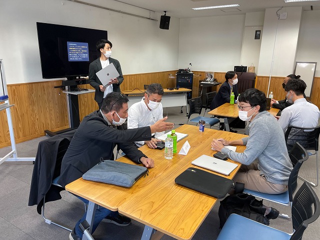 2022年11月に佐賀市内で開かれた22年度「Startup　Boost　SAGA」で参加者を個別指導するNESの今川代表取締役（手前左）ら（NES提供）