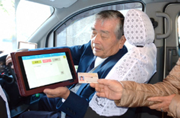 タクシー乗車時にマイナンバーカードを車載機にタッチすると、割引料金で利用することができる（写真はタブレット。現在はスマートフォンを使用）