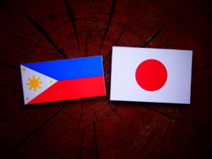Philippines flag with Japanese flag on a tree stump isolated