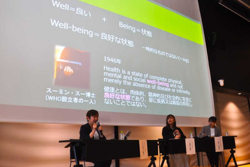 ウェルビーイングの考え方を説明する秋山聡子准教授（左）