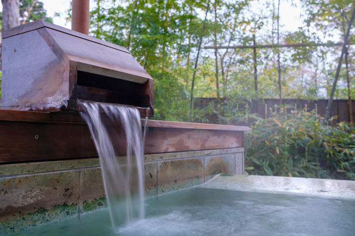Fresh hot spring water filling a bath