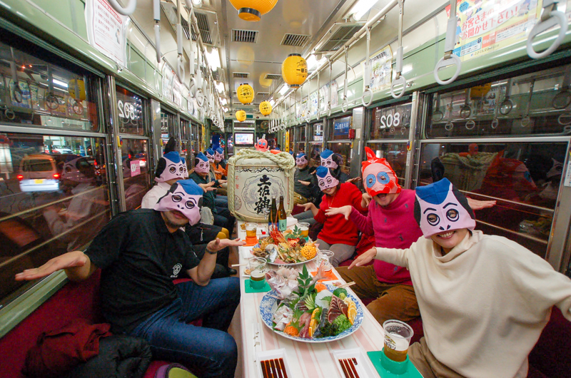 土佐の宴会文化｢おきゃく｣のイベントが行われた電車内で酒を飲み交わす人々